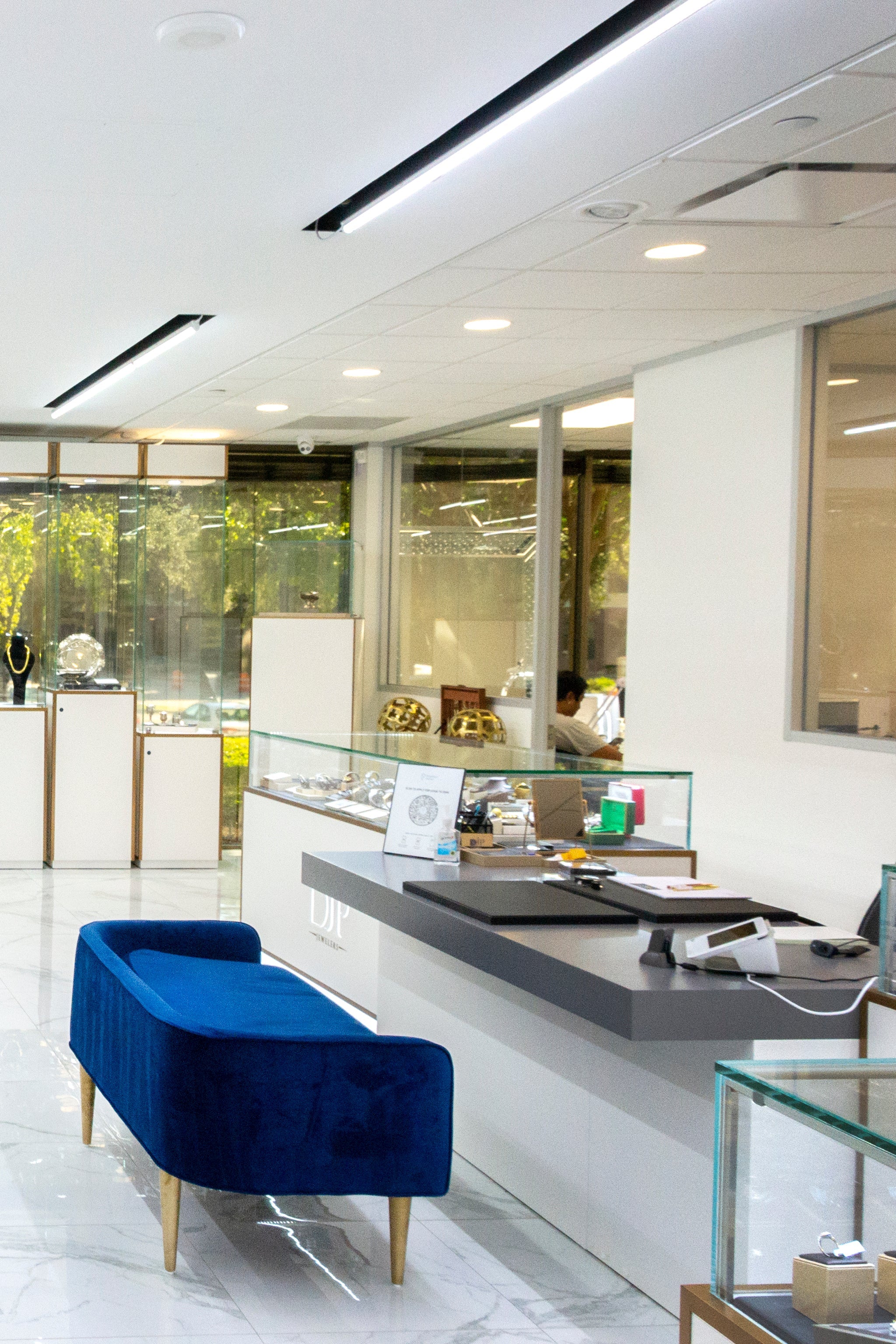 DJP jewelry store interior with blue velvet bench and glass display cases- before the buying process