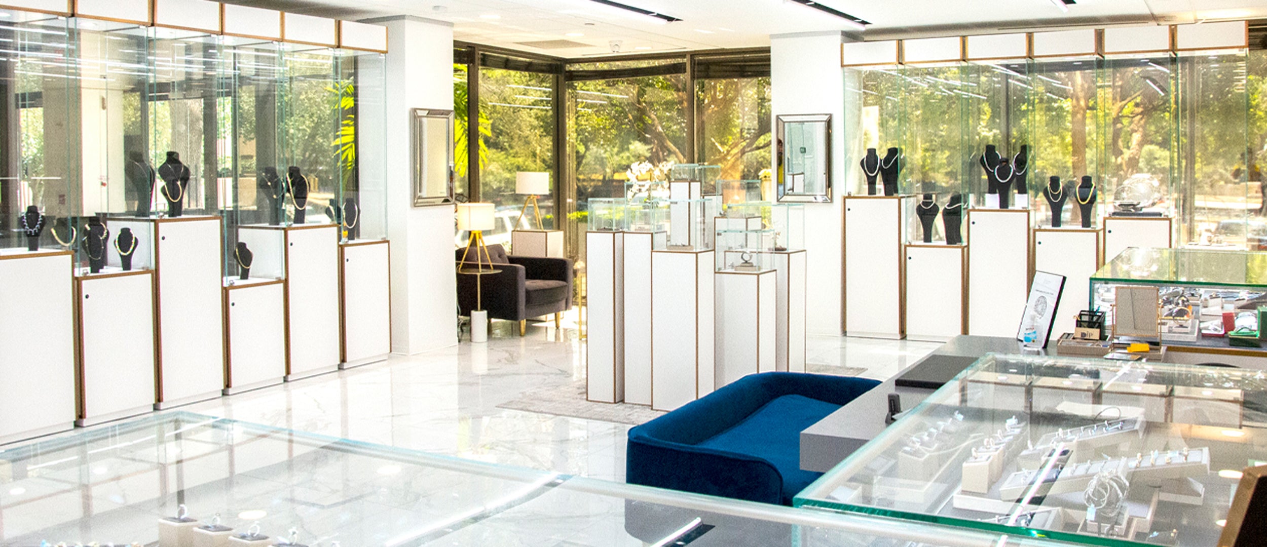 DJP Jewelers & Luxury Buyers - Houston Galleria DJP Headquarters and Houston Store Location - Luxury marketplace for buying & selling jewelry, diamonds, precious metals and bullion. Modern jewelry store interior with glass display cases and blue chair