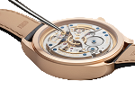 Close-up of a mechanical watch repair with visible gears and tweezers on a light background