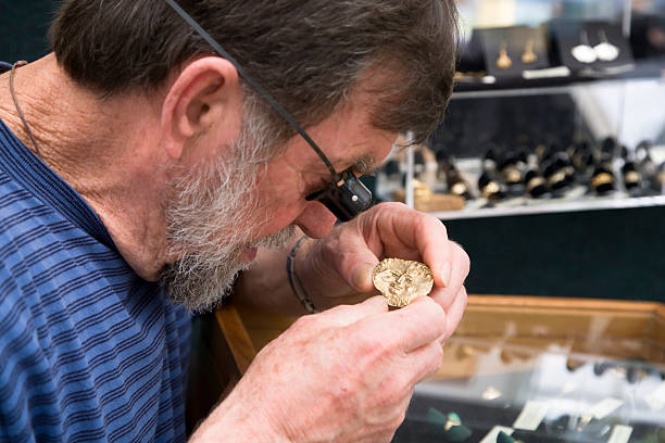 A specialist at DJP Jewelers & Luxury Buyers, a Texas luxury marketplace, inspects a gold jewelry piece with a jeweler’s loupe.