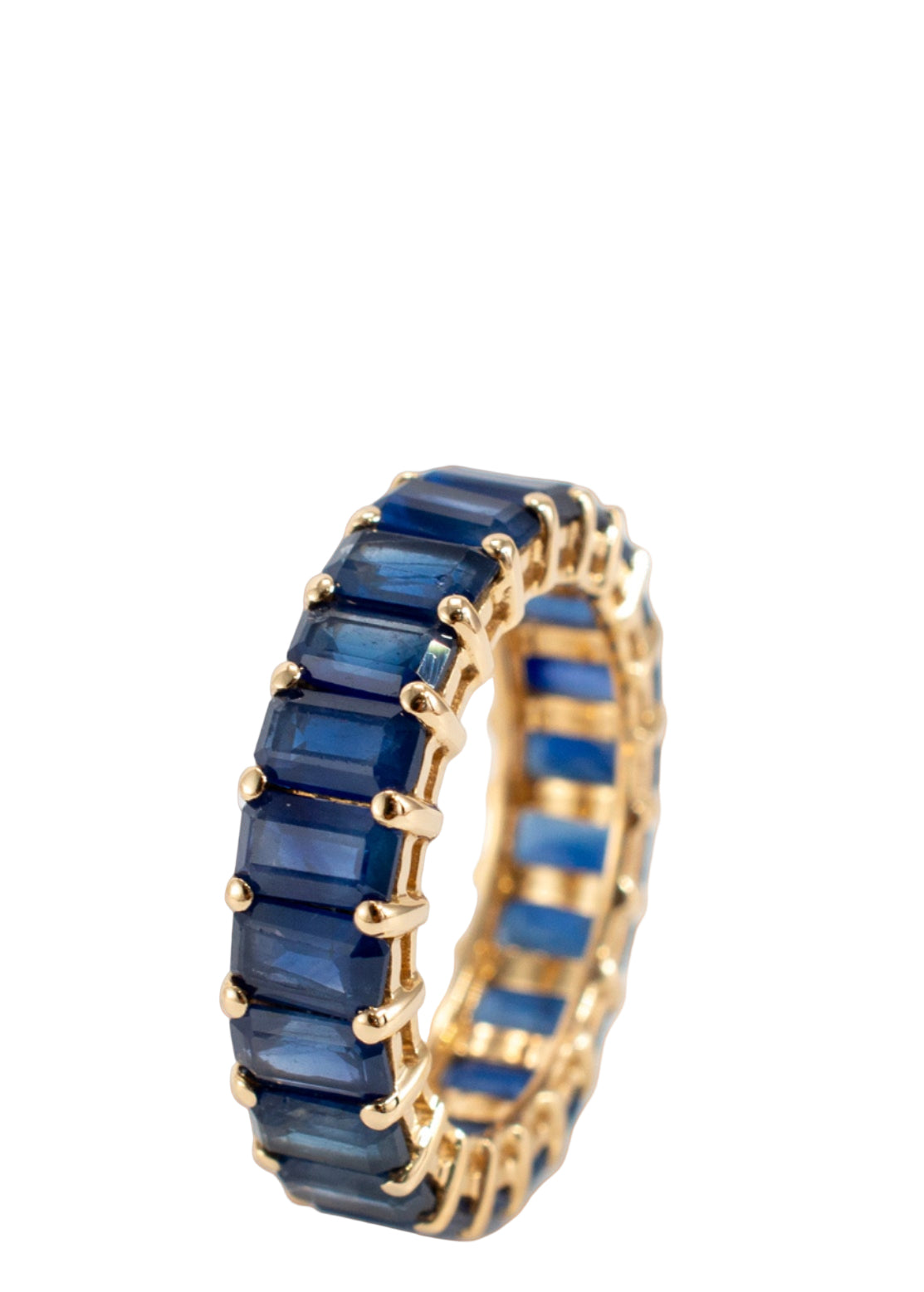 Gold ring with blue gemstones on a peach background