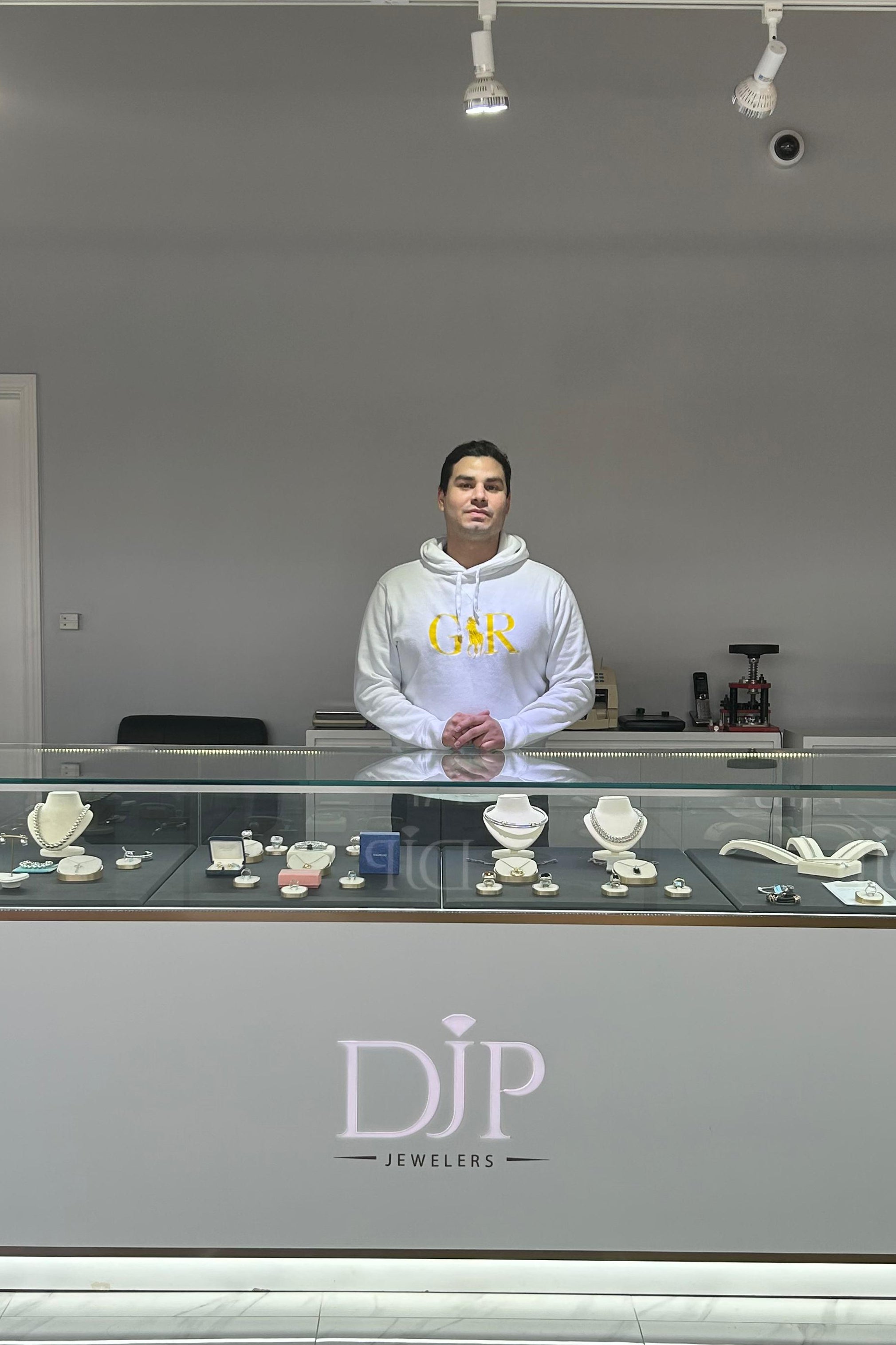 Buyer standing behind the showcase in DJP Jewelers & Luxury Buyers store in Sugar Land- Luxury Marketplace for buying and selling gold, diamonds, jewelry, precious metals, bullion and more 