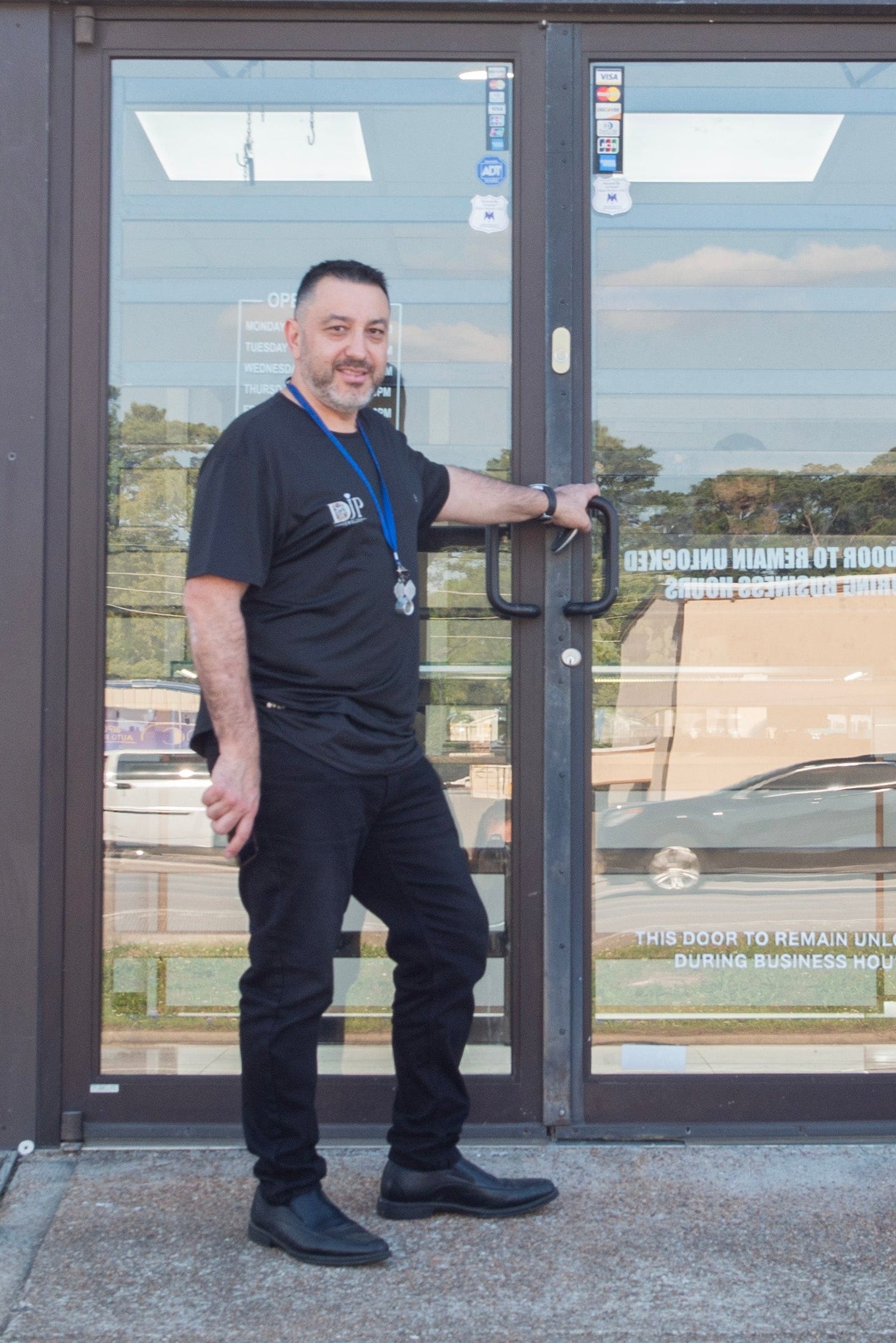 DJP the Woodlands / Spring Manager opening the glass door to DJP Jewelers & Luxury Buyers  -The Woodlands/ Spring store  and welcoming new customers 